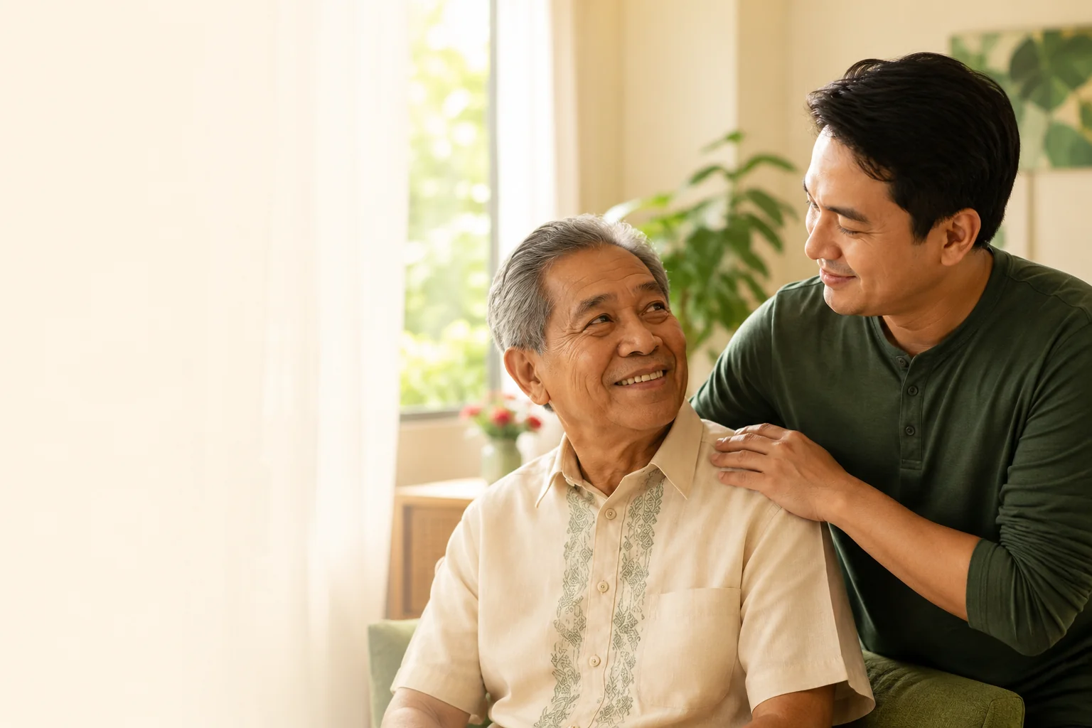 An adult son resting a reassuring hand on his elderly father's shoulder, both smiling